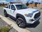 2017 Toyota Tacoma 4x4 extended cab with aftermarket rims and tires parked on a residential street