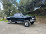 Black 2006 Chevrolet Silverado 2500HD truck with an 8-inch lift and new tires parked outdoors