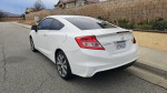 2012 Honda Civic Si coupe in white parked on the street with clear details on the body and surroundings.