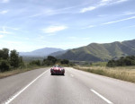 Porsche 365 Speedster replica driving on a scenic road in Santa Barbara, CA, surrounded by mountains.