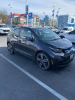 2014 BMW i3 in grey parked, featuring 20-inch rims and Terra package options for electric driving.