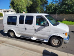 2000 Ford E-150 Triton Camper Conversion Van parked on the street, featuring a clean exterior and spacious design.